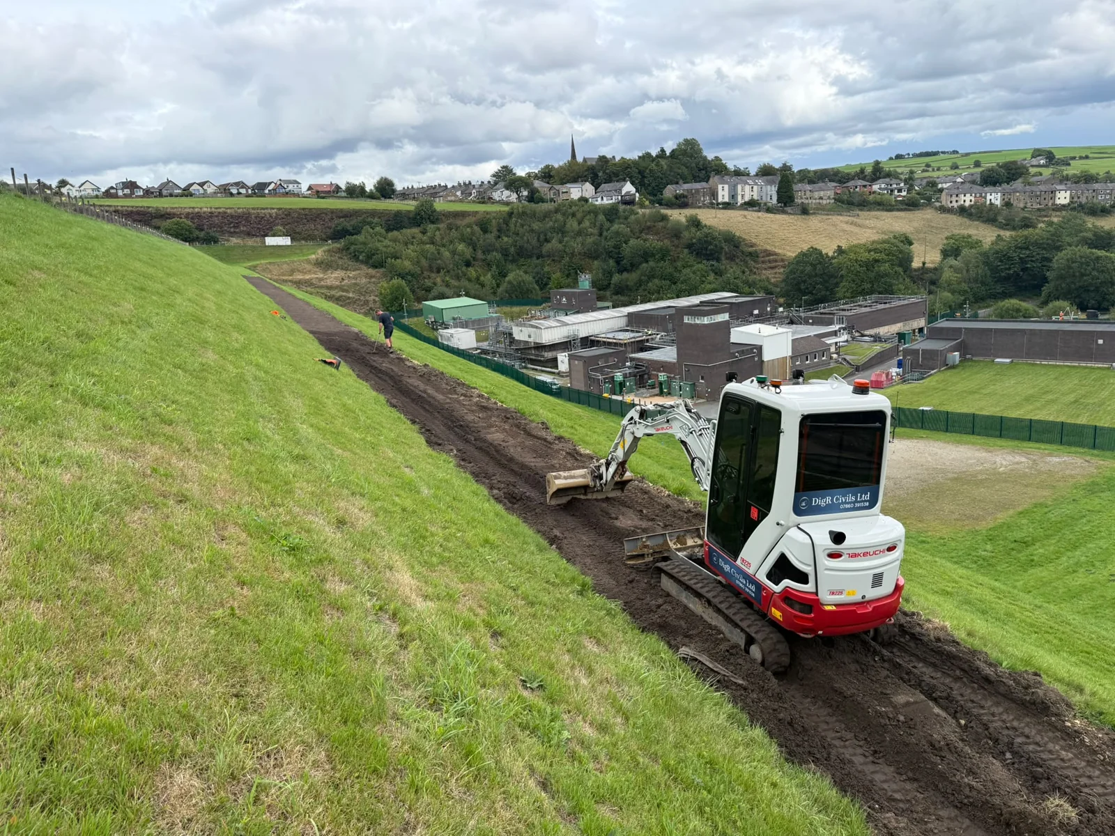 Excavator forming an access track on a hillside