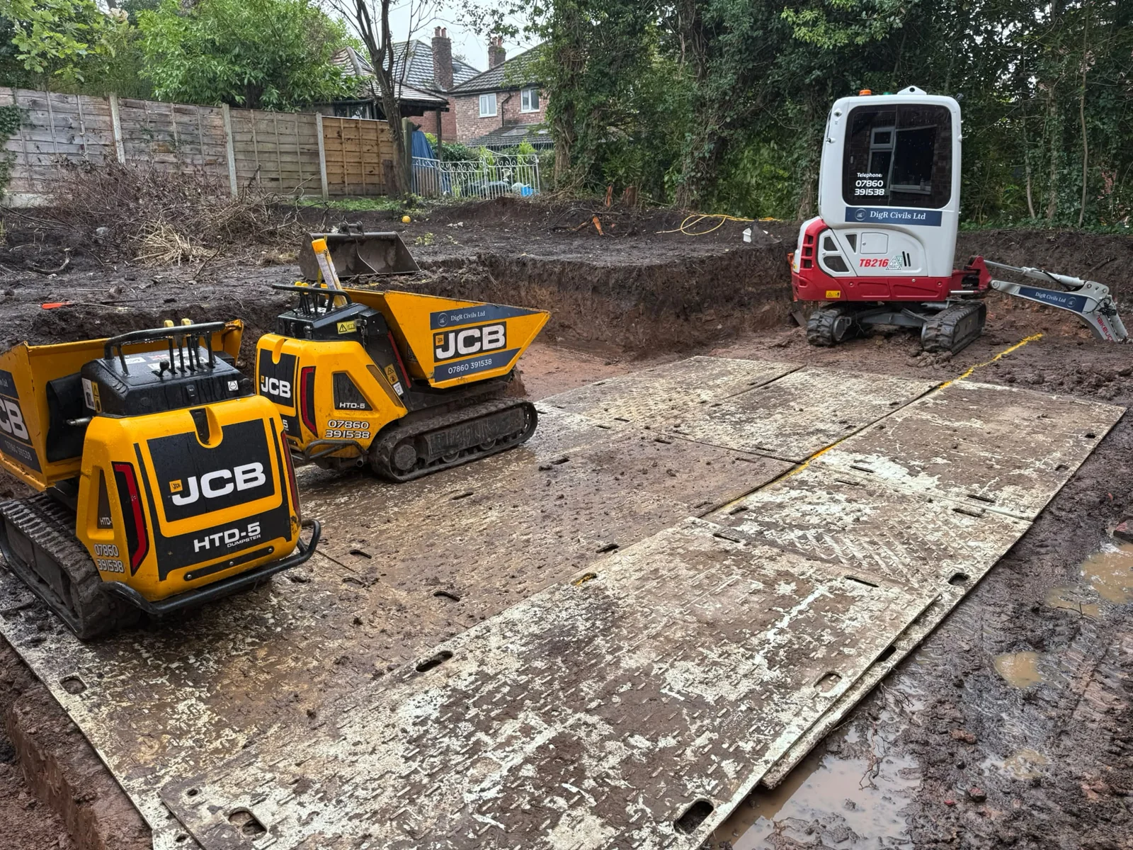 Ground protection boards across the wet working area with tracked dumpers and a mini excavator