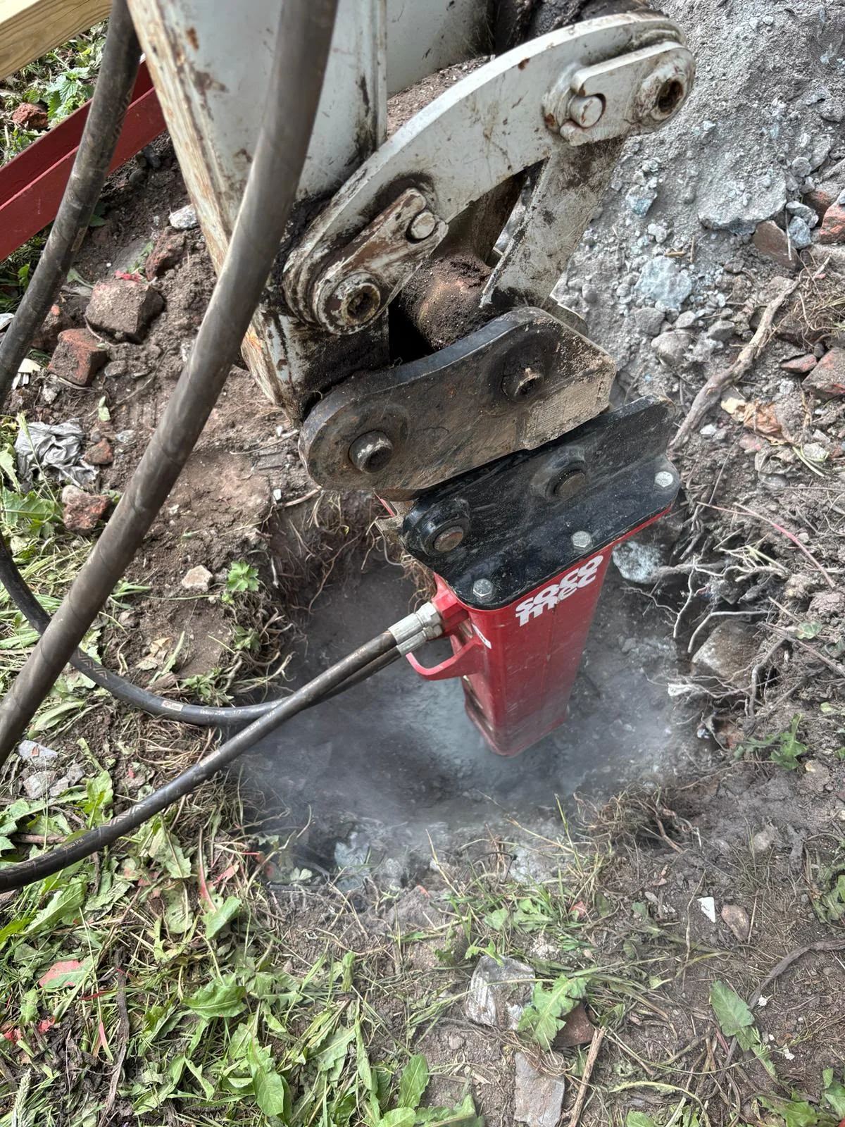 Hydraulic breaker removing hard material at a Manchester site