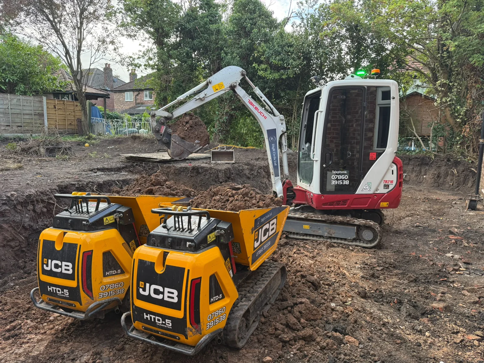 Mini excavator and two tracked dumpers working on a residential excavation