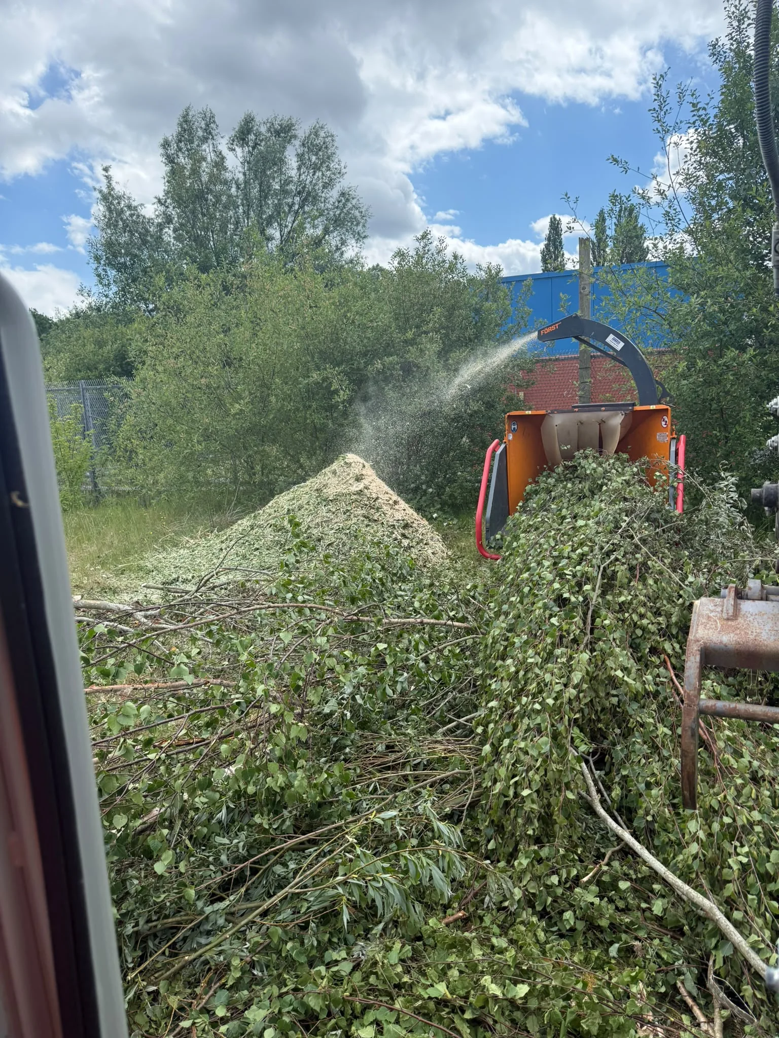 Wood chipper working through branches at a clearance site